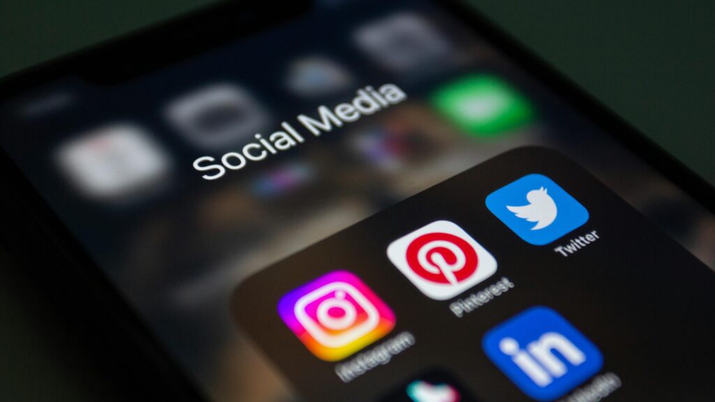 A close-up shot of a phone with the social media apps showing on the screen