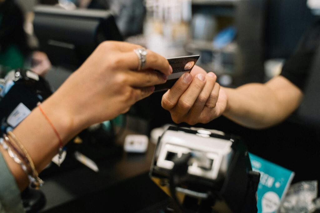 A hand handing over a credit card