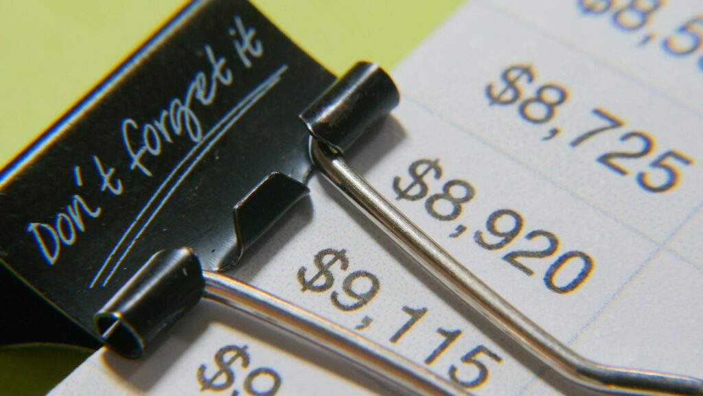A binder clip labeled "don't forget it" on an unpaid invoice