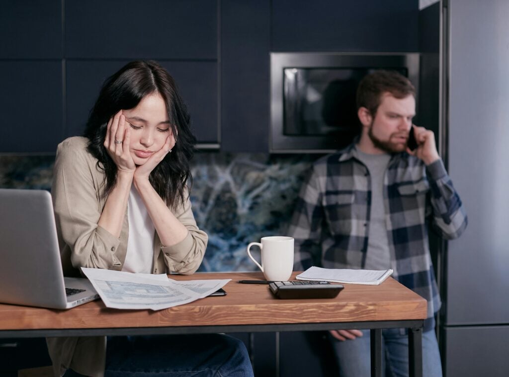 Small business owner stressed over financial tax burden, head in hands at desk