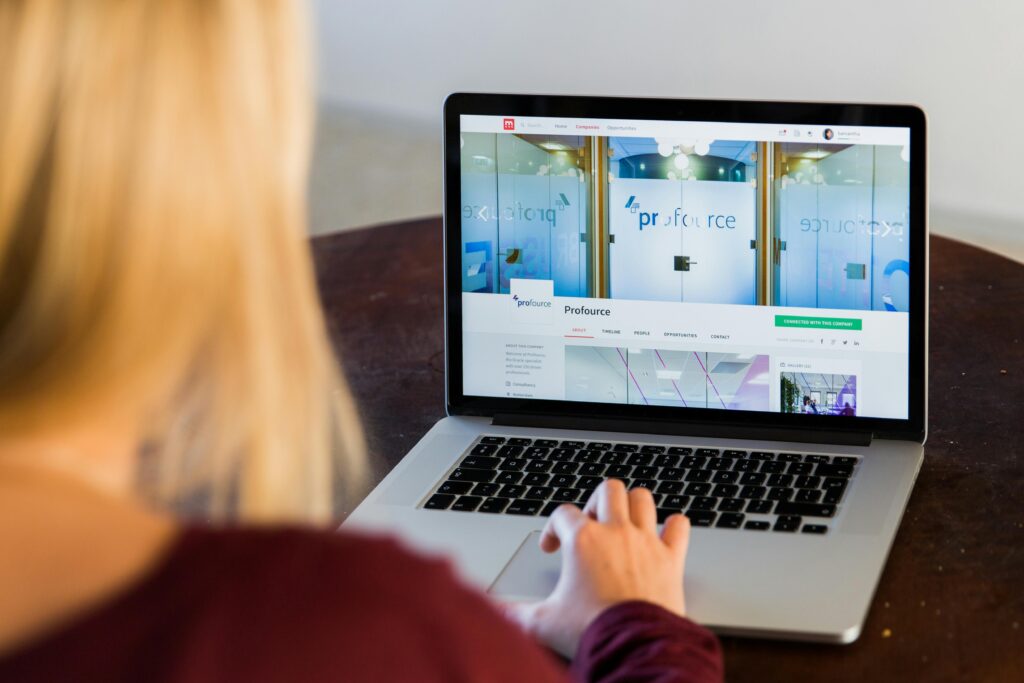 A woman on her laptop with a website showing up on her screen