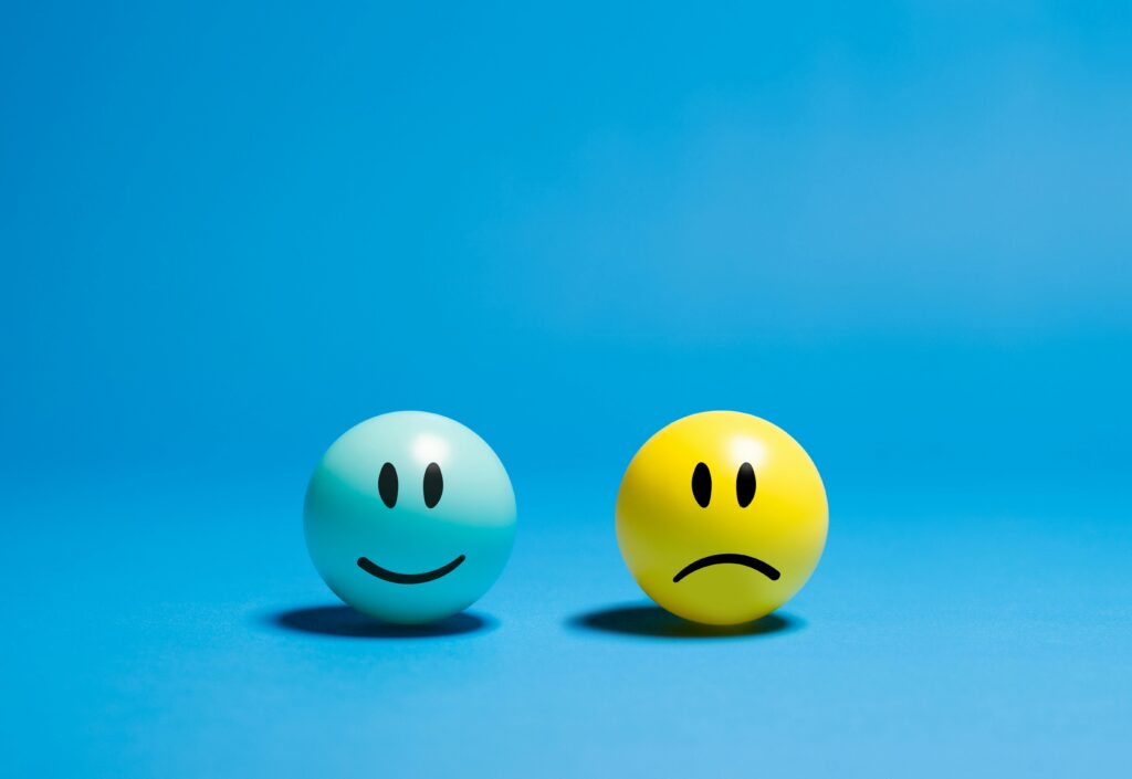 A happy and sad emoji ball representing positive and negative feedback